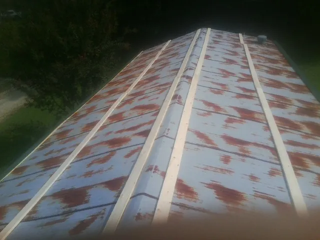 Rusted metal roof panels with new wood purlins before replacement — Storm Damage Roof Repair in Franconia by Roofing Brothers