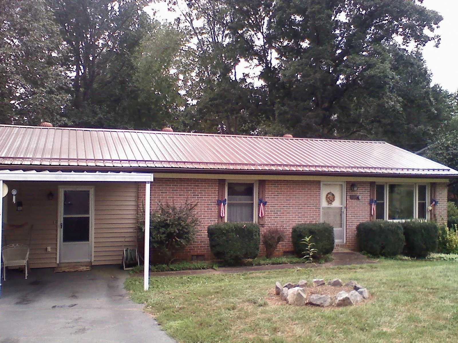 Bronze metal roof and carport on a brick ranch home — Roof Repair work by our crew in Franconia